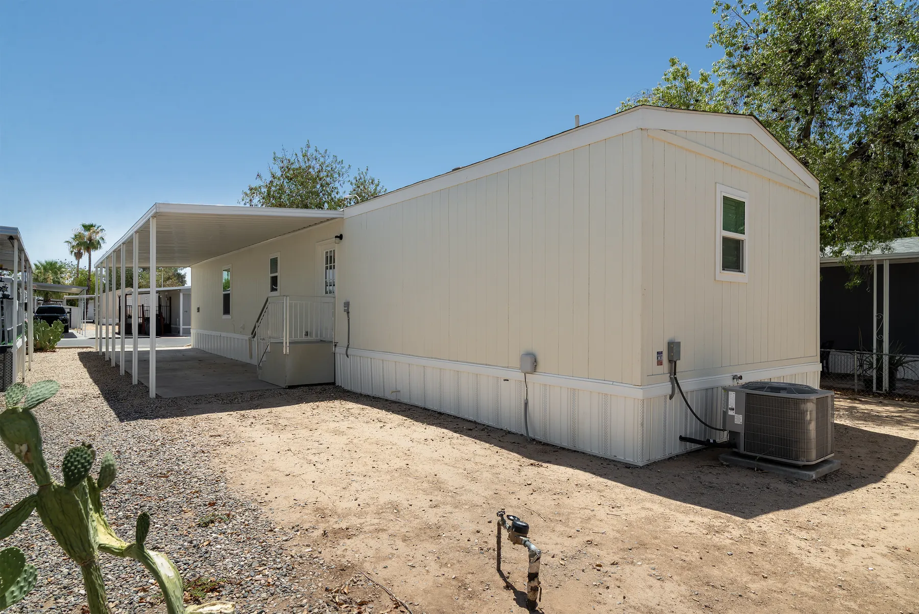 Rear of the home with A/C unit and side steps